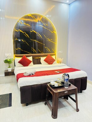 Habitación de hotel con cama, mesita de noche y un diseño de mármol en la pared.