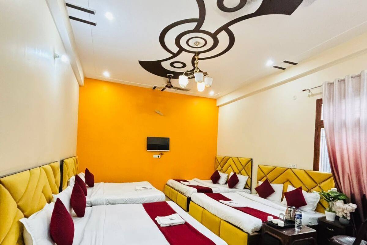 A hotel room with two beds, a ceiling fan, a flat-screen TV, and a small table with a chair.