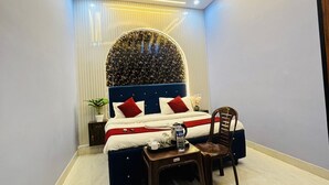 A modern bedroom with a bed, a desk, and a chair. - Vedas Villa (Faizabad)
