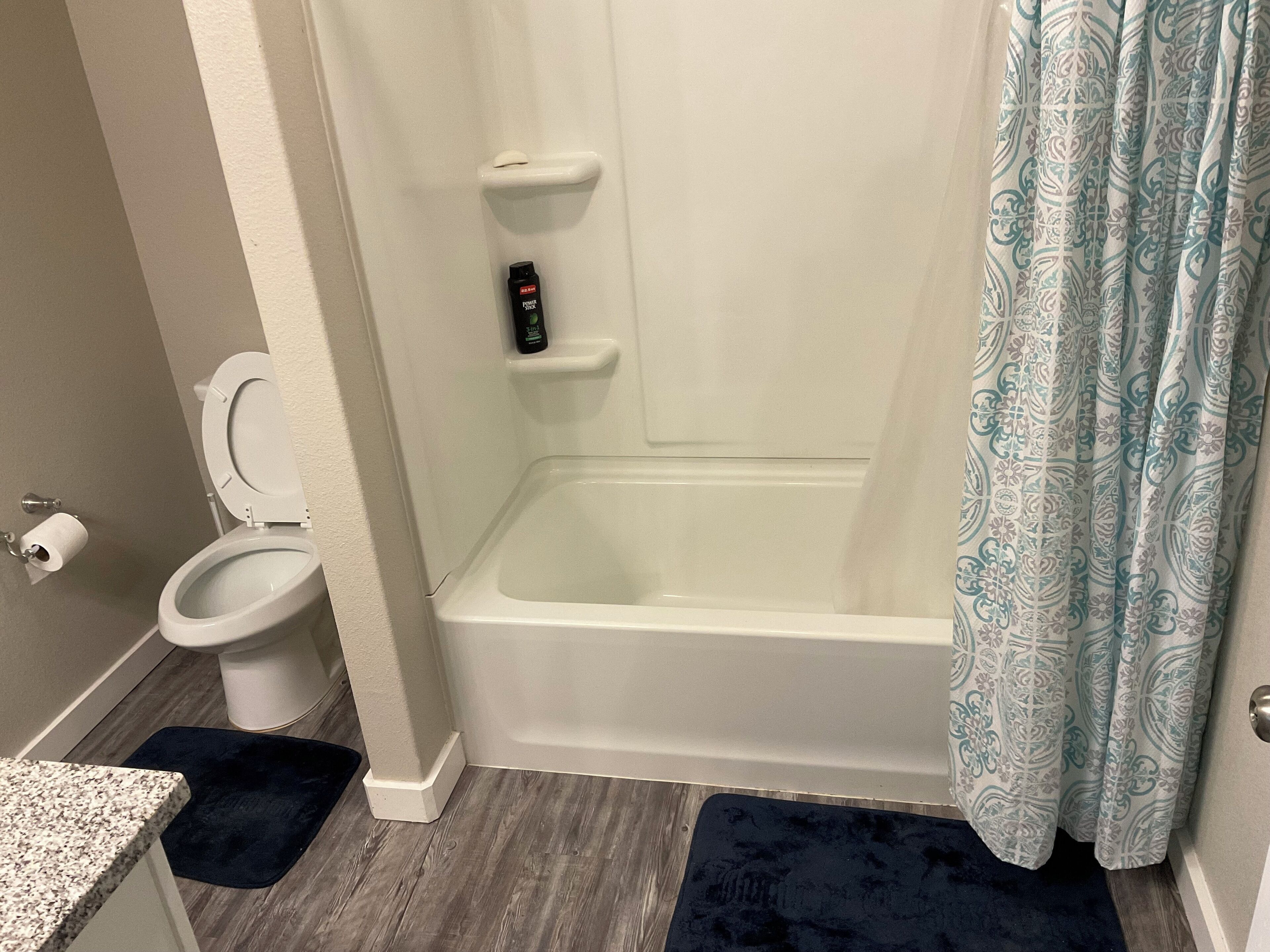 Een badkamer met toilet, douche en bad.