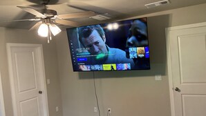 Televisor de pantalla plana montado en la pared mostrando una interfaz de transmisión de películas.