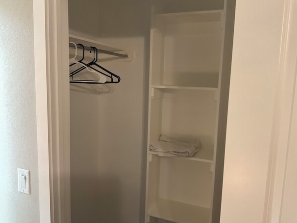 A closet with hanging space and shelves.
