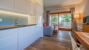 Una cocina moderna con armarios blancos, encimera de granito y grifo de acero inoxidable.