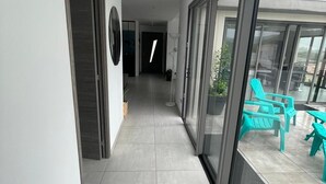 A modern hallway with a view to an outdoor patio area.
