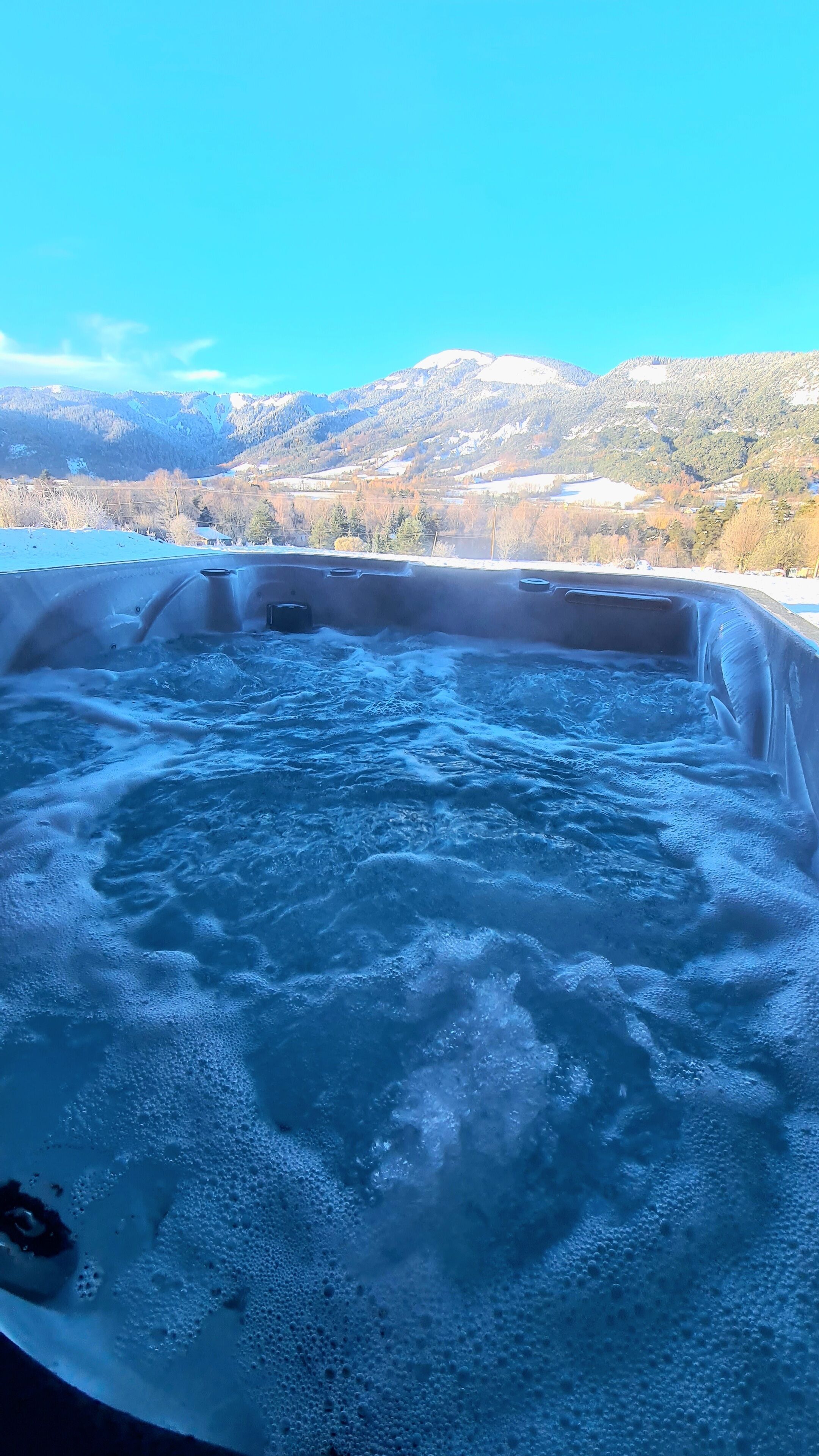 Un jacuzzi con vistas a un paisaje montañoso.