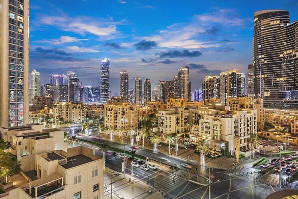 A cityscape with high-rise buildings, a well-lit street, and a clear sky.