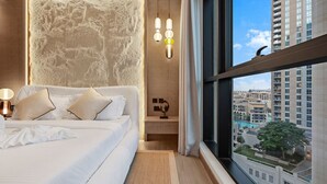 Une chambre moderne avec un grand lit, un mur à texture, une vue sur la ville et un luminaire suspendu.