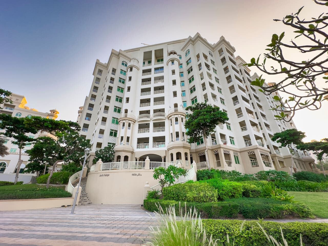 A multi-story hotel with a central courtyard, balconies, and a staircase leading to the entrance.