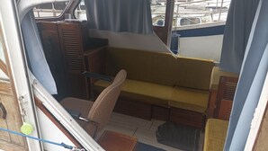 A compact living space with a sofa, a small table, and a cabinet. - Vedette hollandaise 9m a quai a l'entrée de Redon  (Redon)