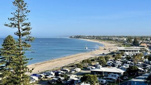 Eine Küstenlandschaft mit Strand, blauem Himmel und einer Reihe von Mobilheimen.