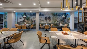 A restaurant with indoor seating, a bar area, and a decorative wall with a waterfall feature. - A25 Premium Hotel - 65G Nguyen Thai Hoc (Ho Chi Minh City)