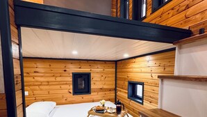 A compact, wooden cabin-style room with a bunk bed, a small table with breakfast items, and built-in shelves. - Sapanca Tiny Home (Sapanca)