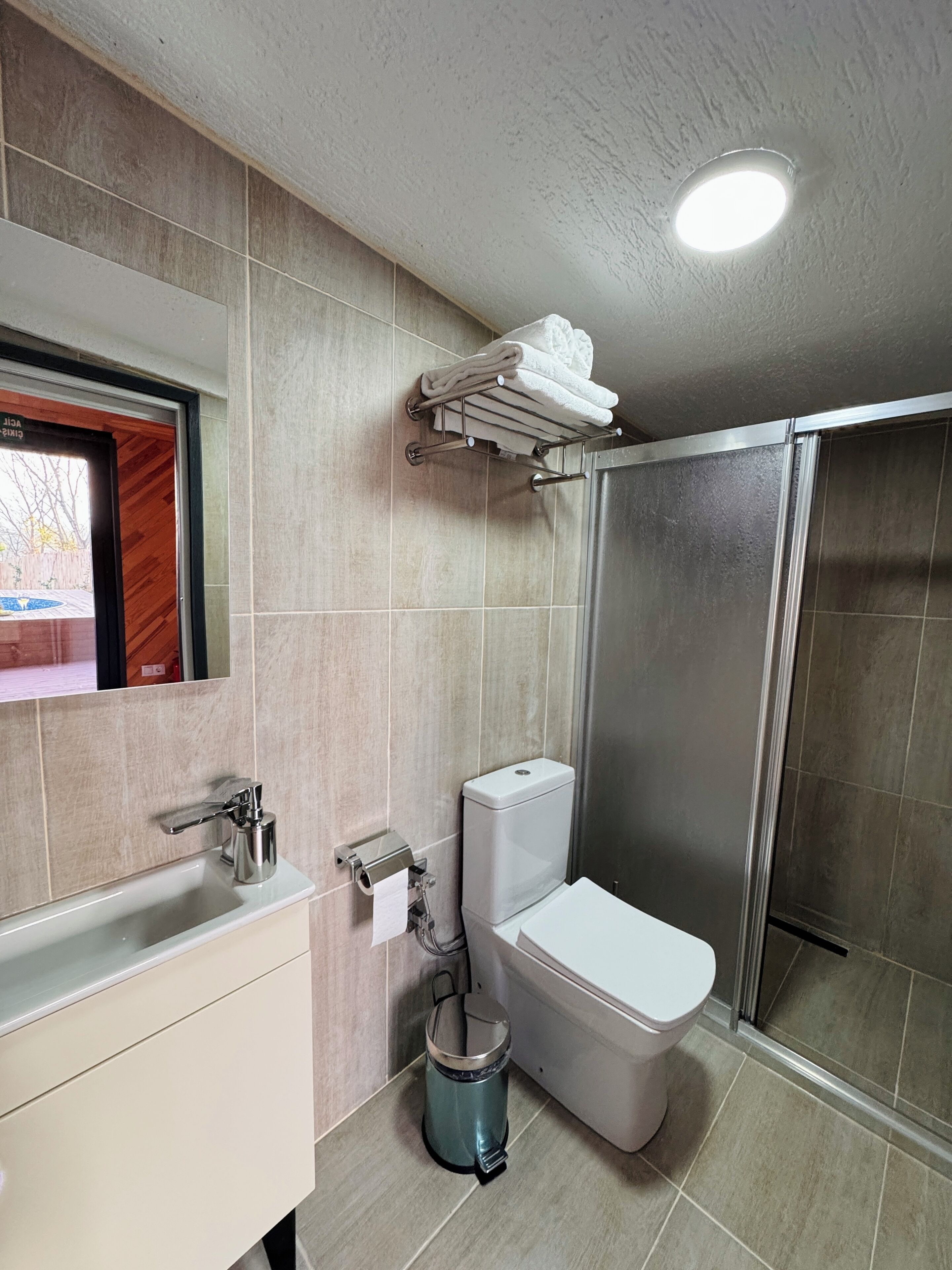 A modern bathroom with a toilet, sink, and shower.