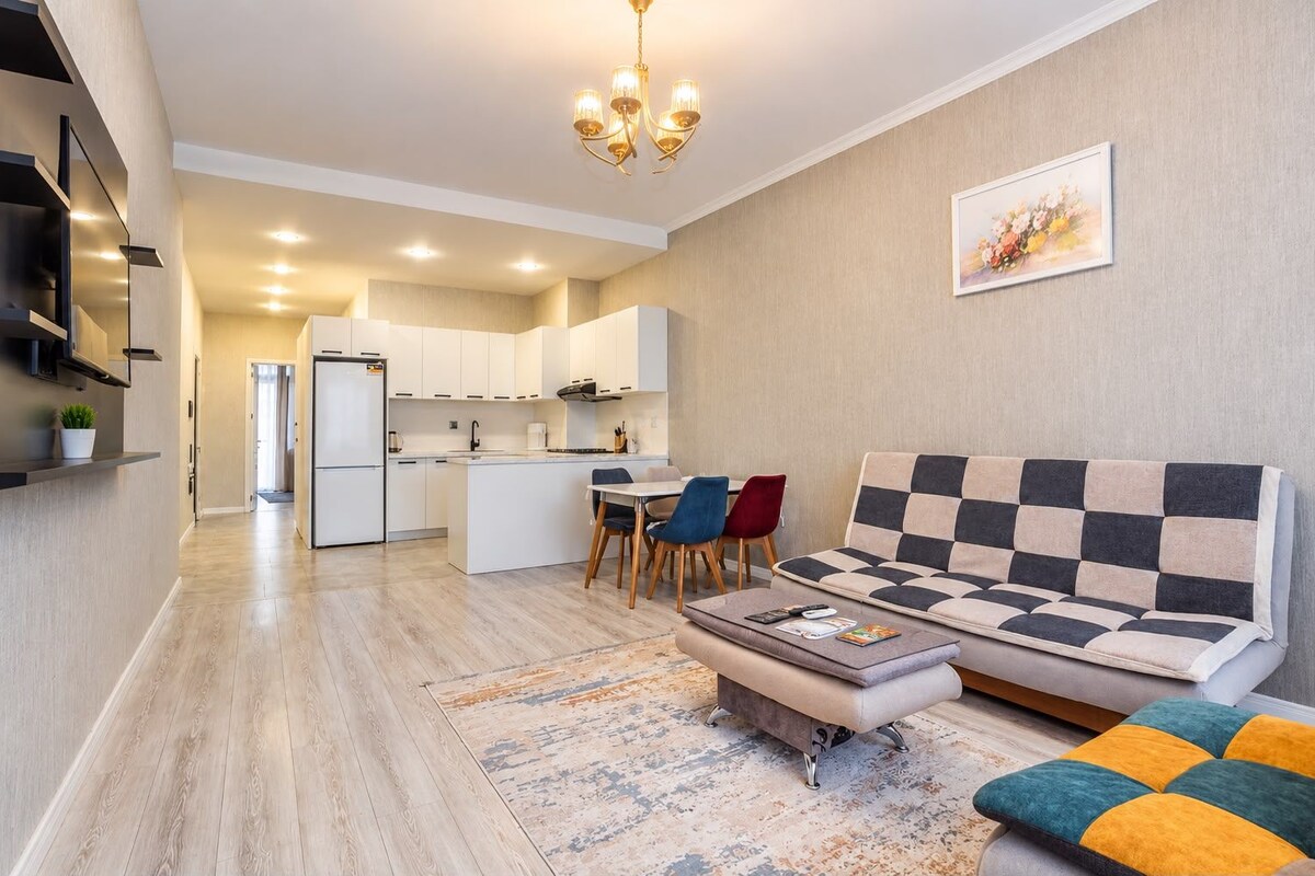 A modern living room with a sofa, a coffee table, and a dining area with chairs.