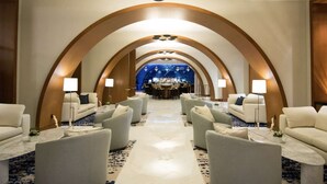 A hotel lobby with a central bar, arched ceiling, and seating areas.