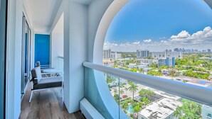A balcony with a view of a cityscape, including buildings and palm trees. - Luxury 1 /1.5 condo perfect for beach vacation (Fort Lauderdale)