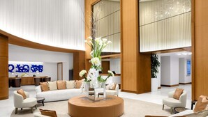 A spacious lobby with a central round coffee table, sofas, and a reception desk. - Luxury 1 /1.5 condo perfect for beach vacation (Fort Lauderdale)
