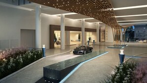 A modern hotel lobby with a car parked in the center, a water feature, and a large wooden canopy overhead. - Luxury 1 /1.5 condo perfect for beach vacation (Fort Lauderdale)