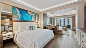 A hotel room with a large bed, a desk, and a view of the city.