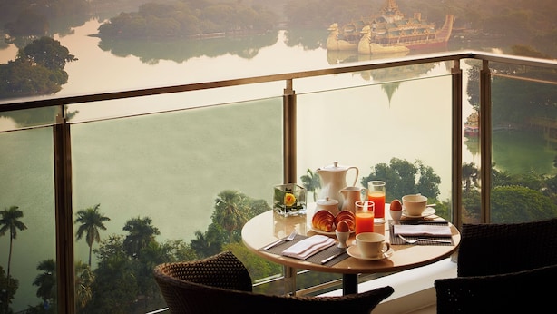 A dining table with breakfast items and a view of a temple and river. - Shangri-La Serviced Apartments, Yangon (Yangon)