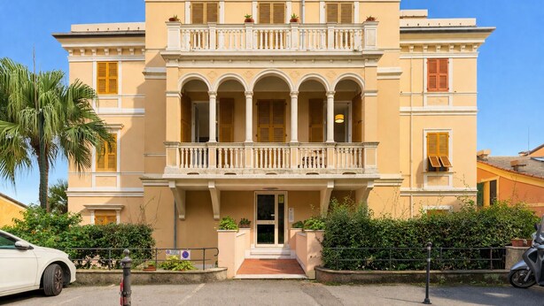 A two-story building with a balcony, arched windows, and a front entrance. - Casa con Accesso Privato al Mare Parcheggio Bogliasco (Bogliasco)