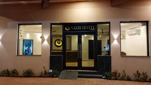 The exterior of Nazri Hotel with a modern entrance, a visible reception area, and a well-lit facade. - Nazri Hotel (Arambol)