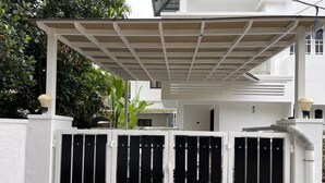 A gated entrance with a white fence and a covered porch.