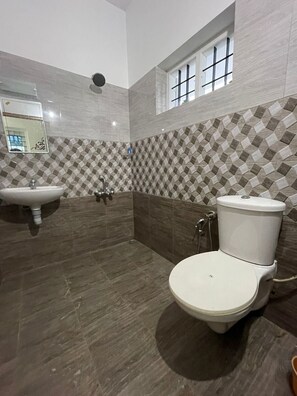 Un baño con lavamanos, inodoro y zona de ducha.