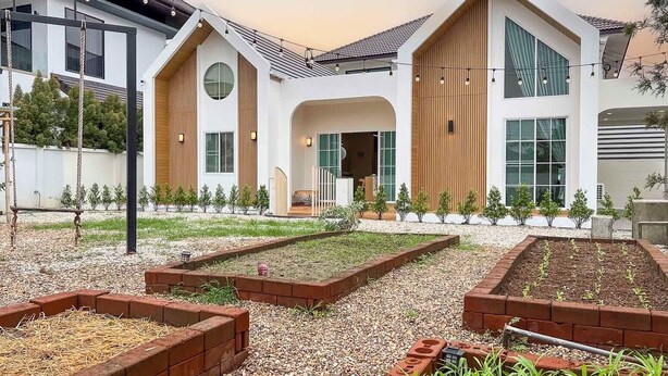 A modern house with a large central patio, a wooden sloped roof, and a white exterior.
