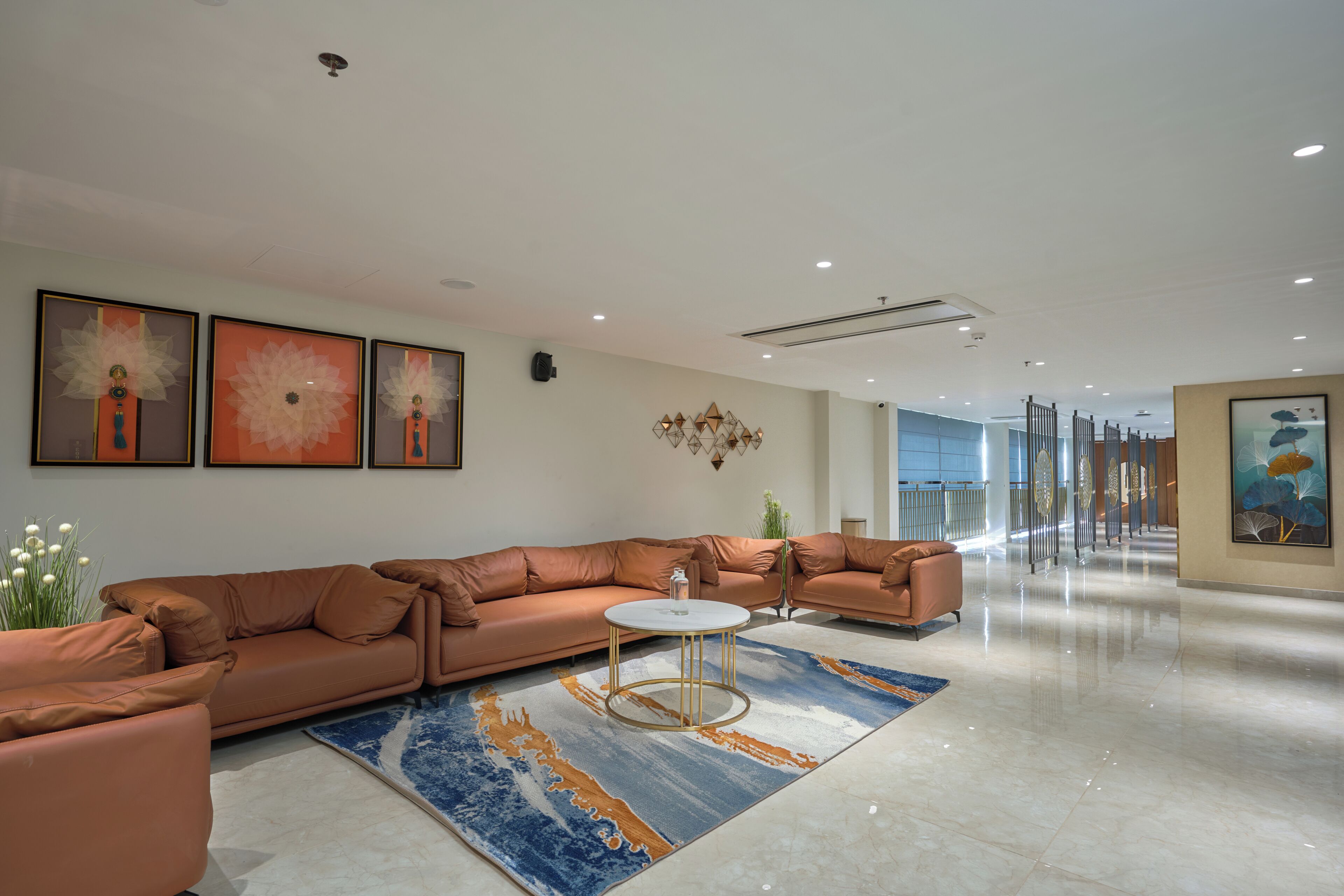 A modern lobby with a large sectional sofa, a round coffee table, and a patterned rug.