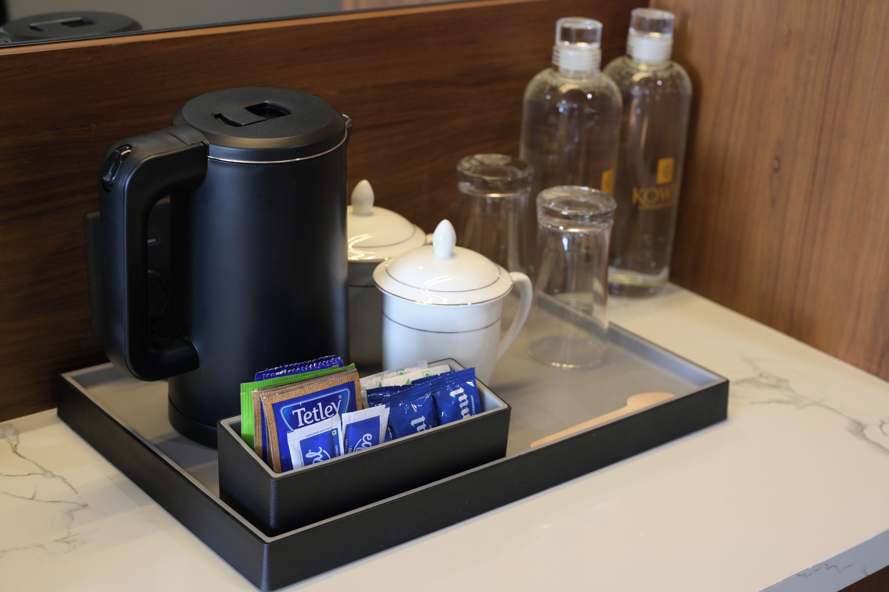 Een dienblad met een koffiezetapparaat, een suikerpot en een waterfles.