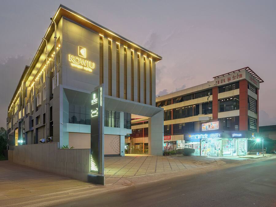 A modern hotel with a prominent entrance and a second-story balcony.