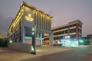 A modern hotel with a prominent entrance and a second-story balcony.
