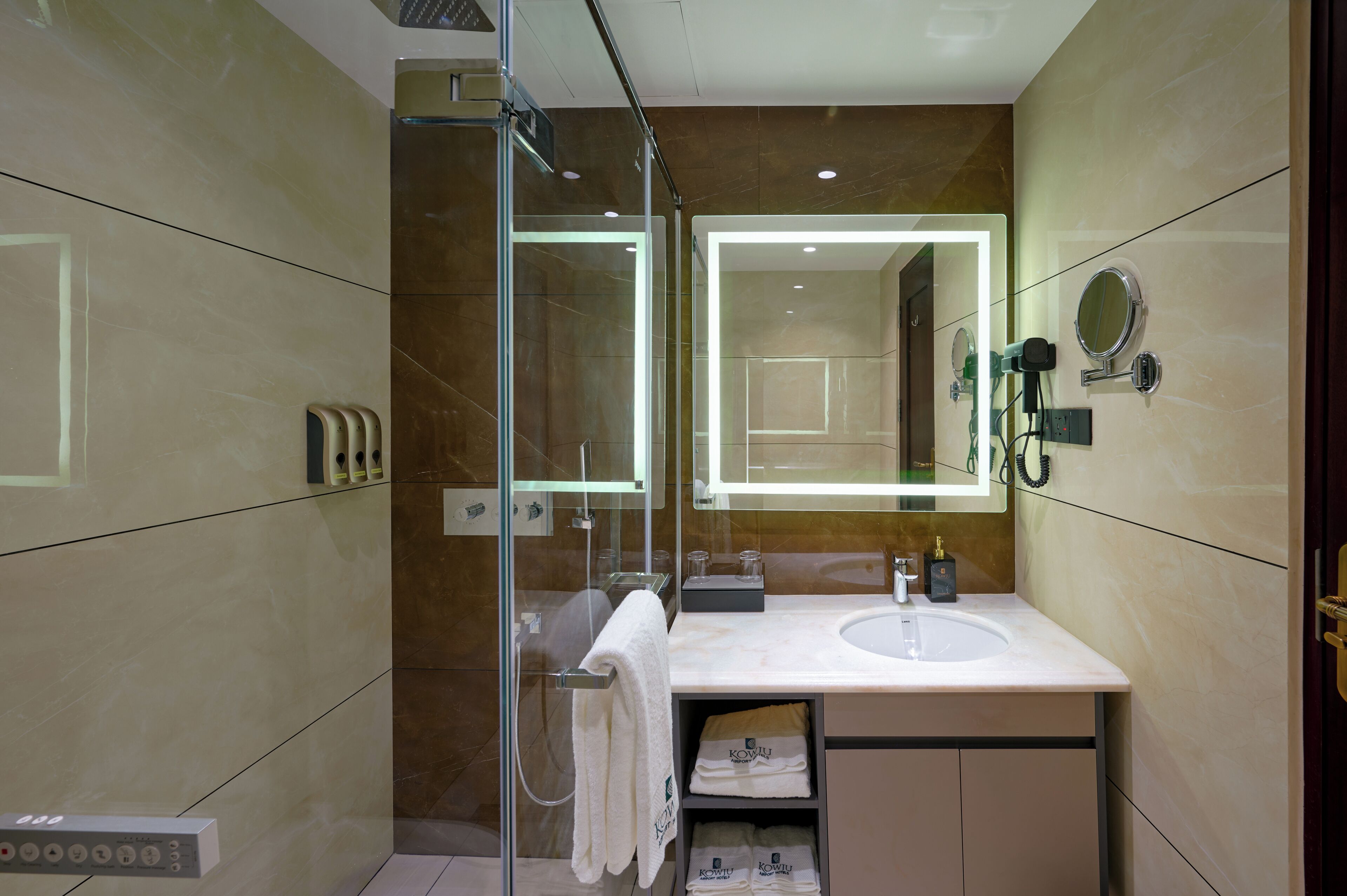 A modern bathroom with a glass-enclosed shower, a vanity with a mirror, and a towel rack.