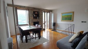 A spacious living area with a dining table, a sofa, and a fireplace. - CasAle sul Lago di Como: serene house with beautiful view of Lake Como  (Blevio)