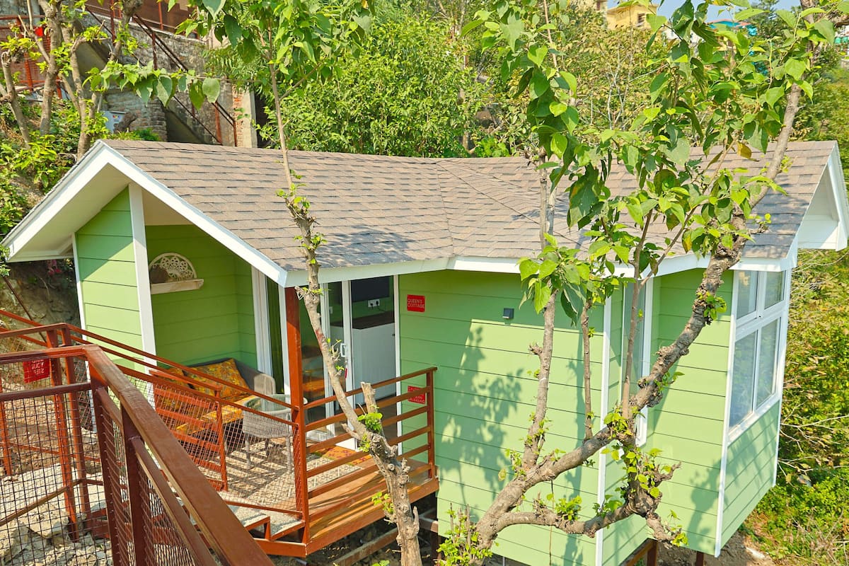 A small, single-story cabin with a porch and a staircase leading to the entrance.
