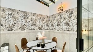 Un coin repas moderne avec une table ronde, quatre chaises et un vase décoratif.