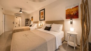 Une chambre d’hôtel avec deux lits, une table de chevet, une lampe fixée au mur et un tableau.