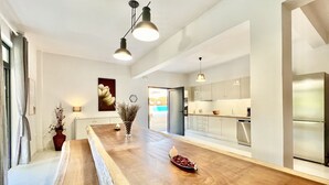 A modern kitchen with a wooden countertop, stainless steel appliances, and pendant lighting.