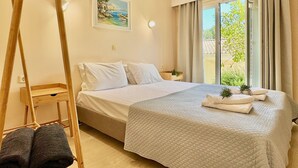 A bedroom with a bed, a wooden ladder, a painting, and a window with curtains.