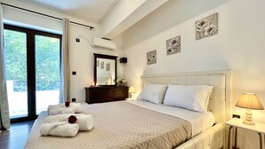 Ein Schlafzimmer mit einem großen Bett, einer Kommode, einem Spiegel und Bildern an der Wand.
