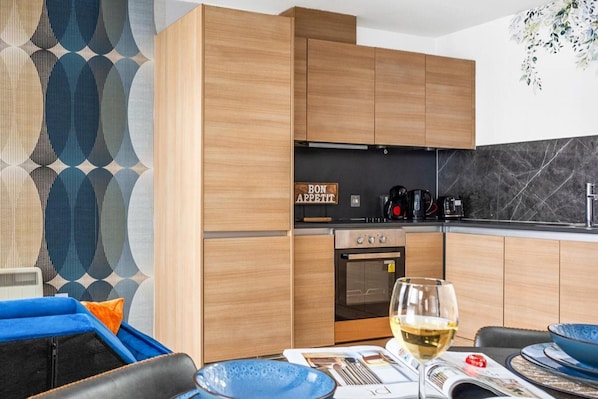 Una cocina moderna con armarios de madera, encimera negra y un cartel que dice "BON APPETIT".