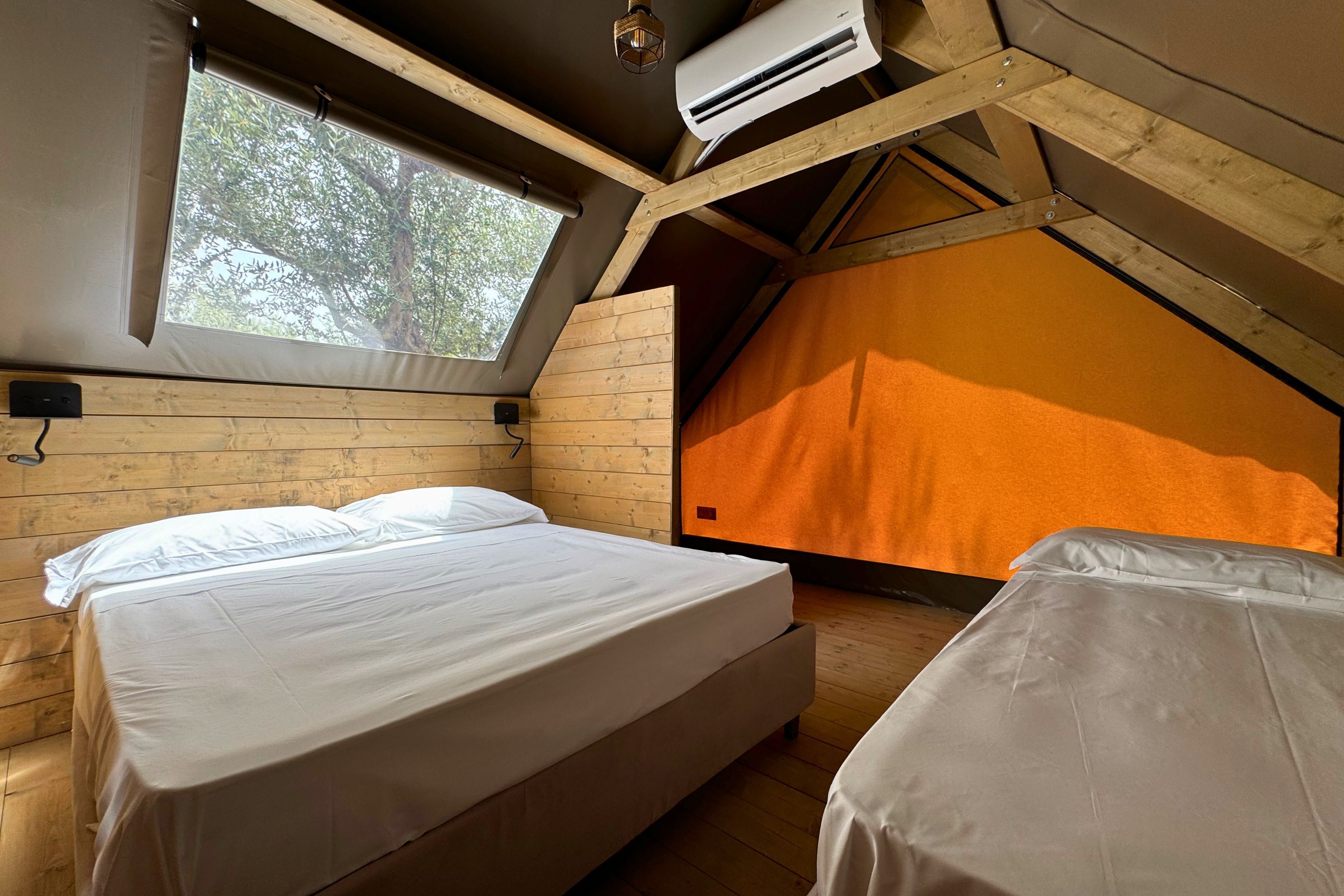Une chambre mansardée chaleureuse avec un plafond en pente, des murs en bois et une grande fenêtre.