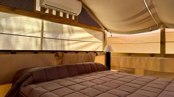 Una stanza accogliente e luminosa con un grande letto, una testiera in legno e una ventola a soffitto.