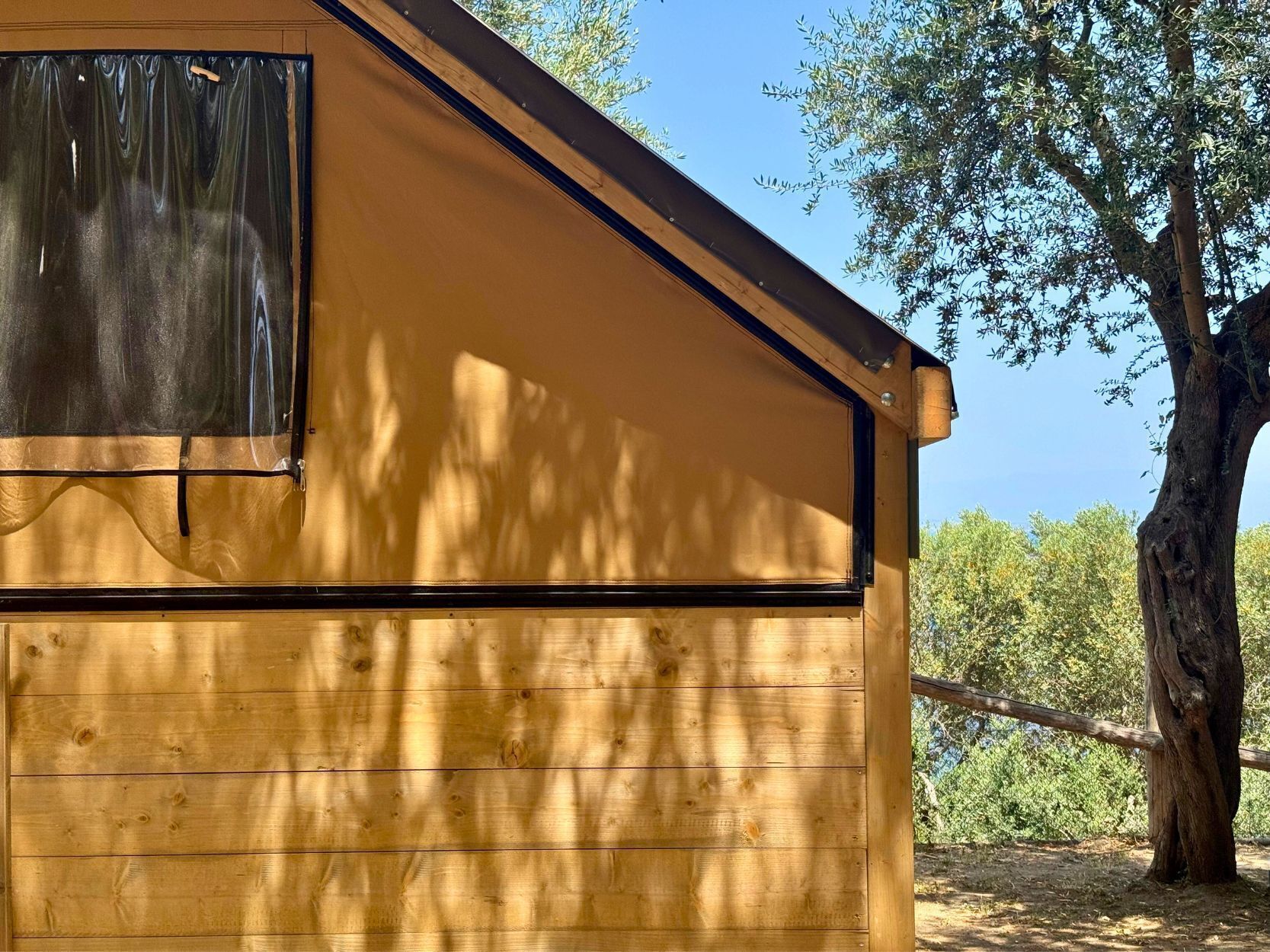 A wooden cabin with a sloped roof and a window.