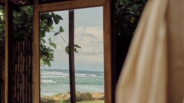 Una stanza in legno con un'ampia finestra vista mare.