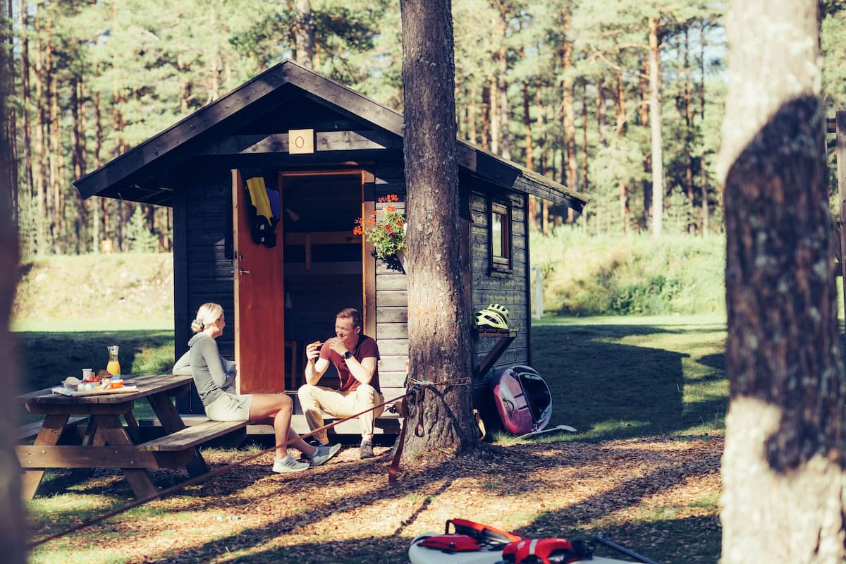 A rustic cabin with a picnic table and a bicycle.