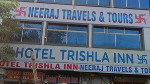 A building with signs for Hotel Trishla Inn and Neeraj Travels & Tours. - Trishala inn (Gwalior)