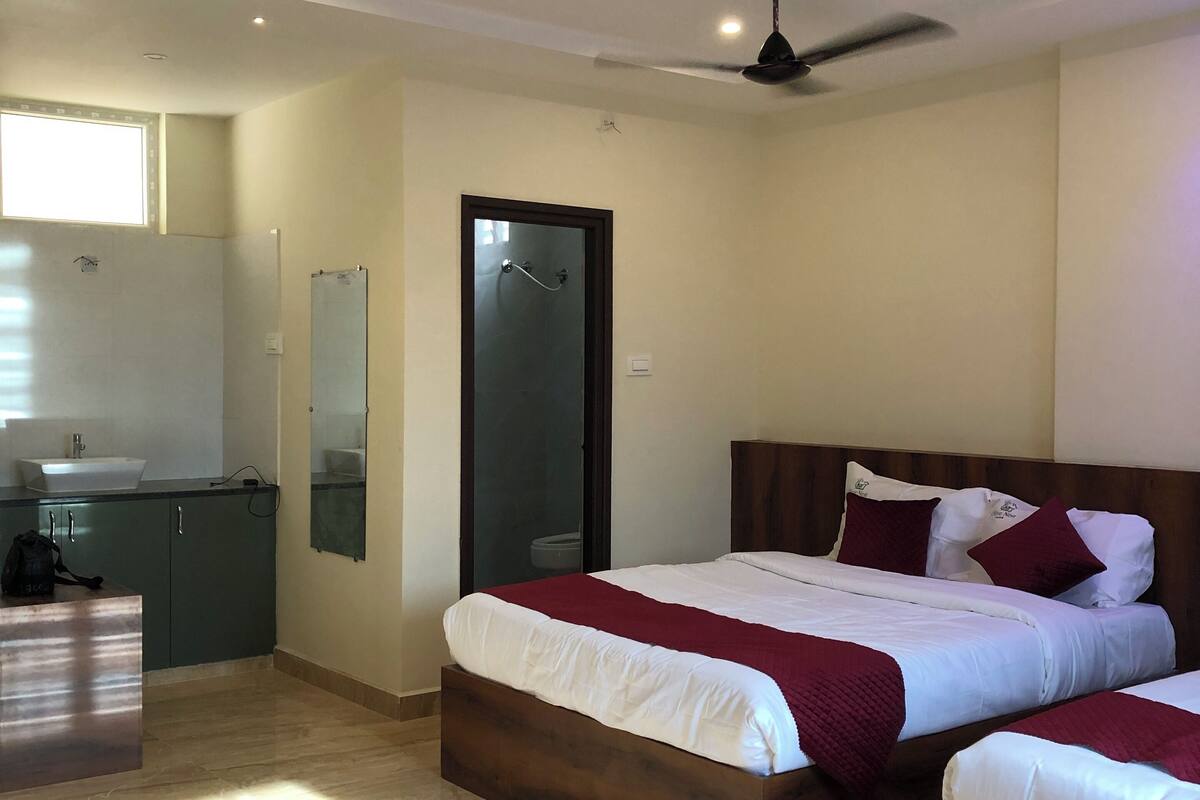 Ein Hotelzimmer mit zwei Betten, einem Badezimmer und einer Küchenzeile.