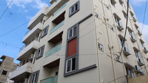 A multi-story building with balconies and windows, featuring a mix of open and closed spaces. - Olive Nest Tirupati (Tirupati)